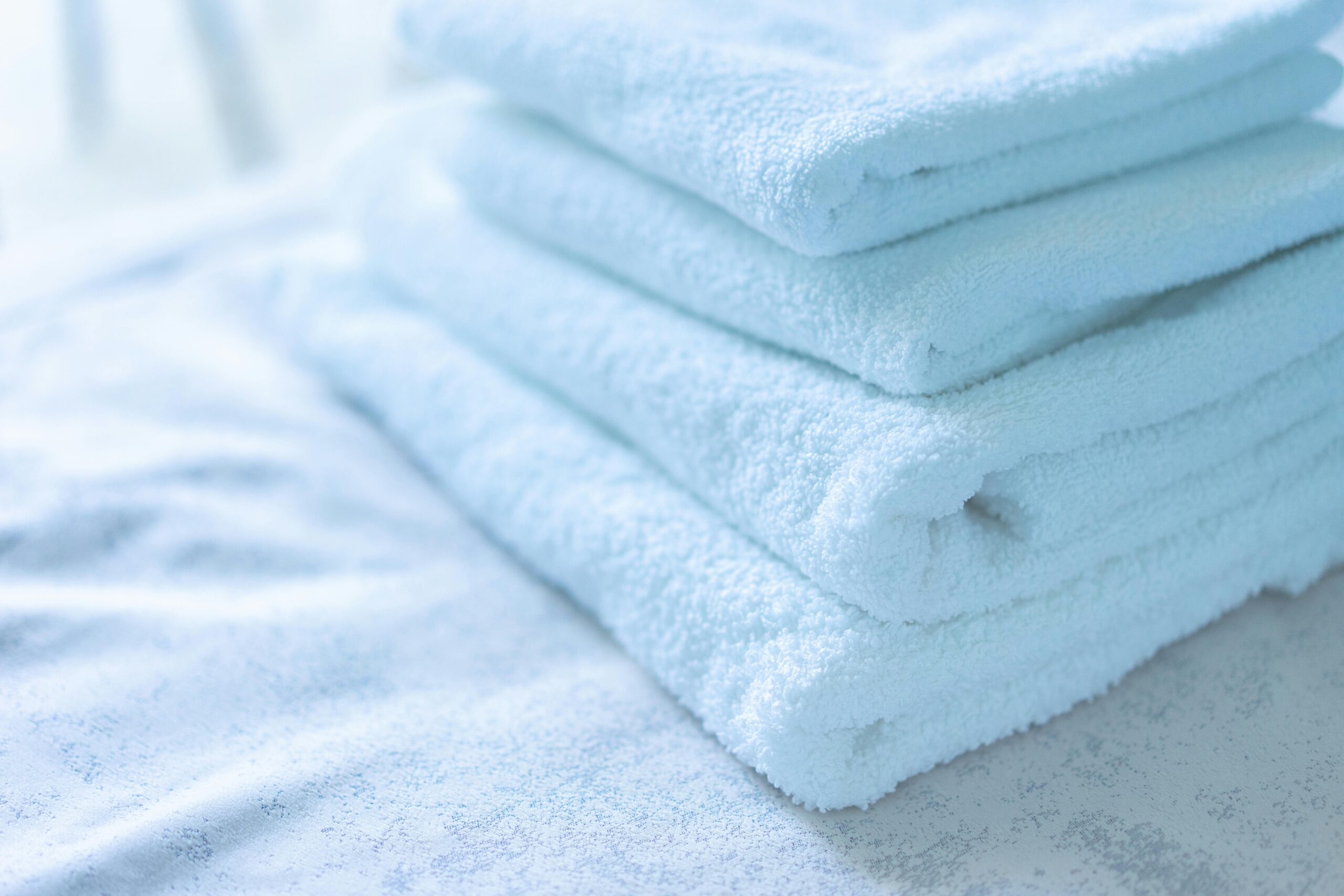 pexels-photo-12932367-12932367 Soft white towels neatly stacked, ideal for spa or bathroom decor themes.