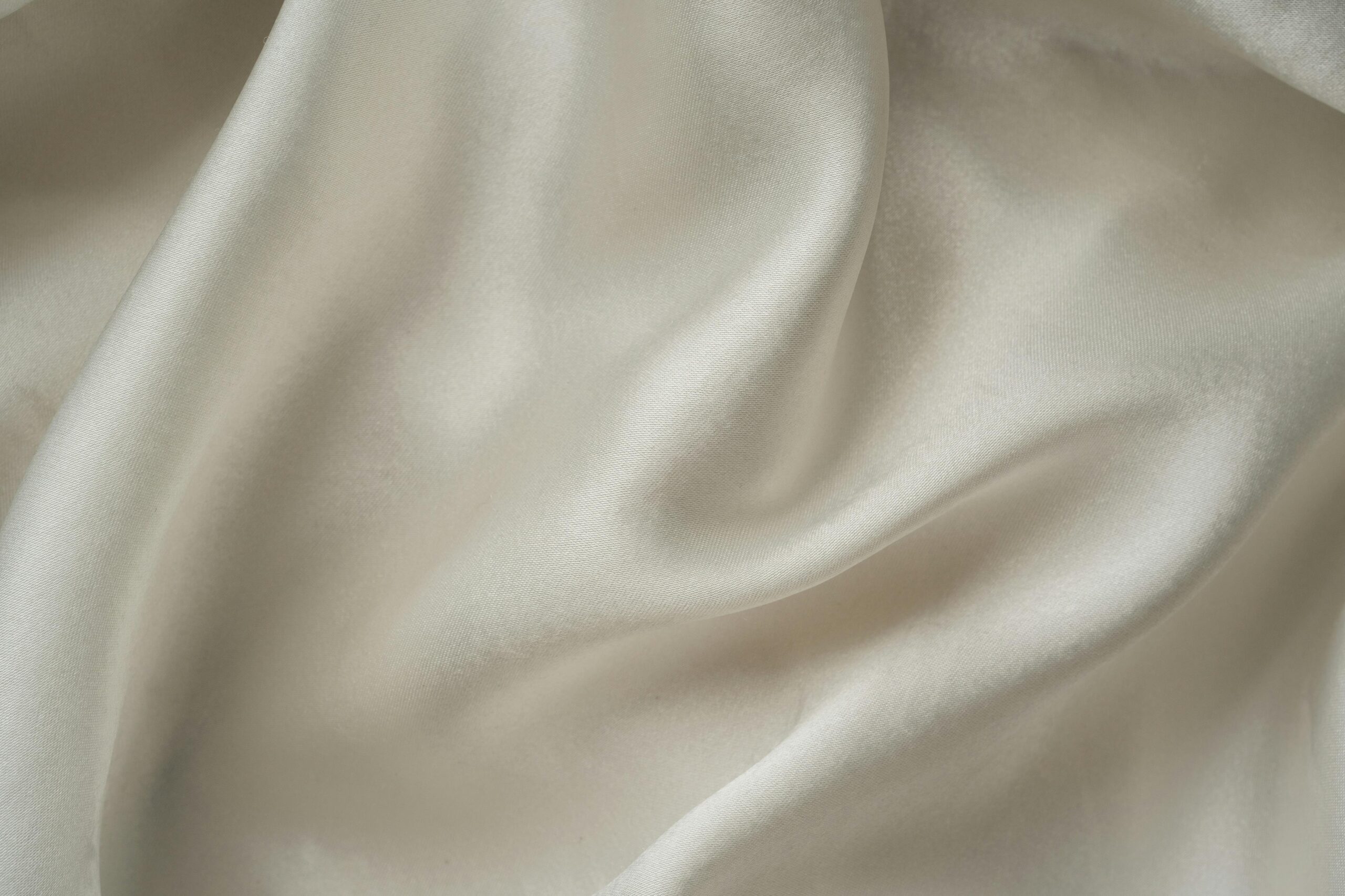 pexels-photo-7717488-7717488 Close-up of smooth white silk fabric with soft folds and gentle draping.